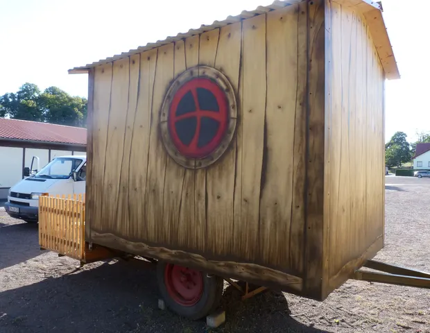 Bemalter Bauwagen mit rundem Emblem